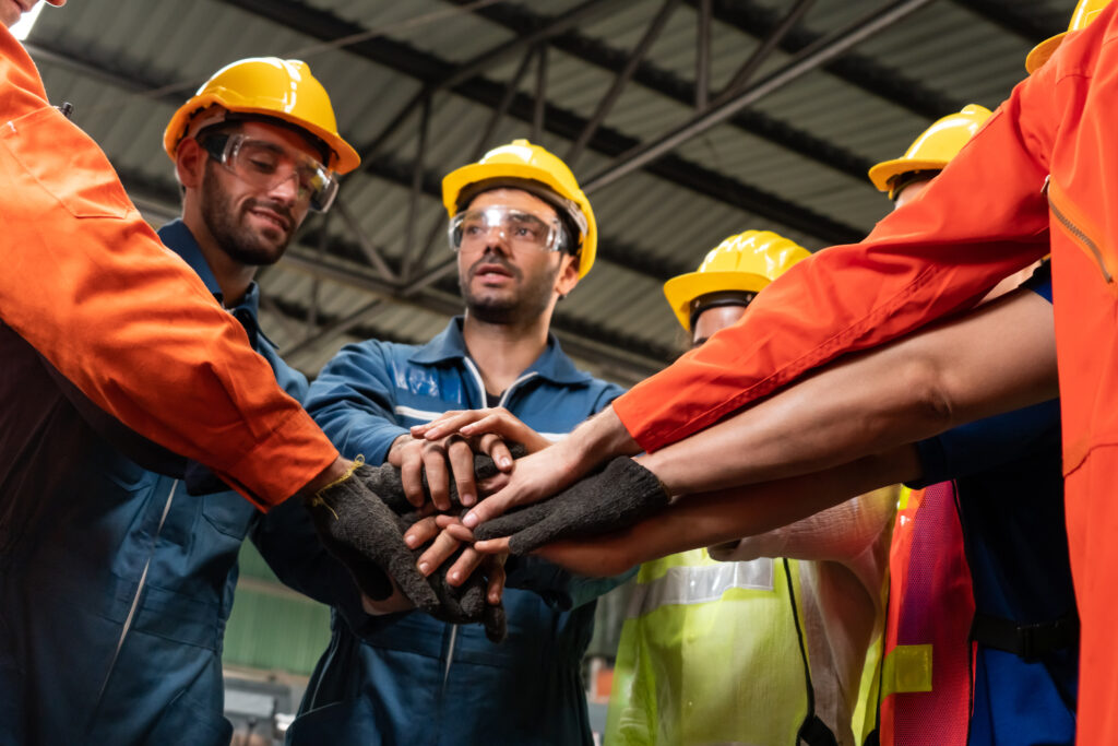 Image of workplace safety where workers hold hands together