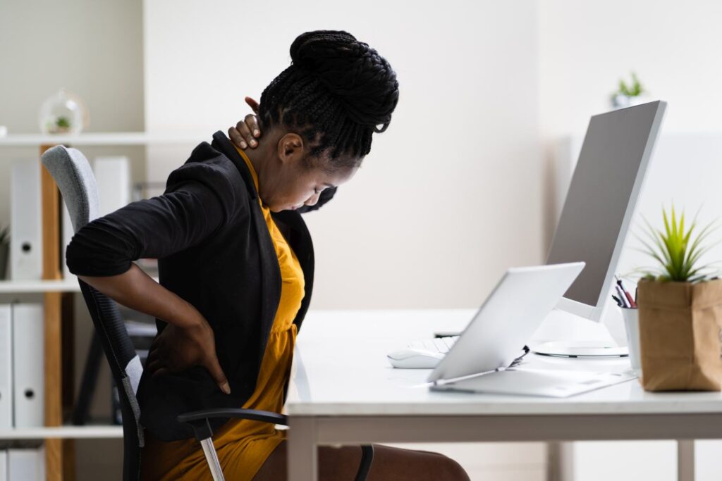 Image of a lady hving backpain because of poor Office Ergonomics Training